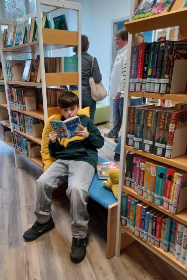 Junge sitzt in der Leseecke im Bereich für die 10-12 jährigen.