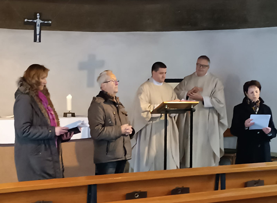 Das Bild zeigt fünf Personen im Altarbereich der Kirche