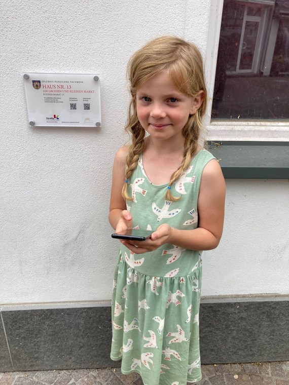 Nora Weber testet die Hörfassung für Kinder mit Papas Handy. (Bild: Stadt Montabaur)