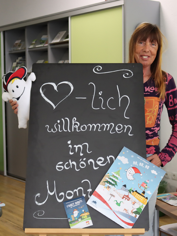 Monti (links im Bild) ist zu Besuch bei Karin Maas in der Tourist-Info in Montabaur. Er hat seinen Schoko-Adventskalender und die neue Stadtrallye „Findet Monti“ mitgebracht. (Bild: Stadt Montabaur)