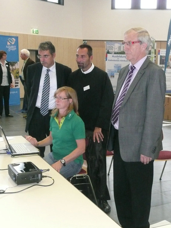 Standfestigkeit und Konzentration muss der Stadtbürgermeister Klaus Mies beweisen. Während er auf einem elektronischen Board die Balance behält, erklärt eine Mitarbeiterin der AOK Bruder Clemens Maria vom Brüderkrankenhaus und dem Ersten Beigeordneten Andree Stein die Auswertung der Ergebnisse.