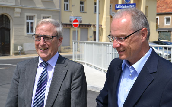 Stadtbürgermeister Klaus Mies und Oberbürgermeister Mike Ruckh begutachten erfreut das Wappen der Partnerstadt am Brückengeländer.