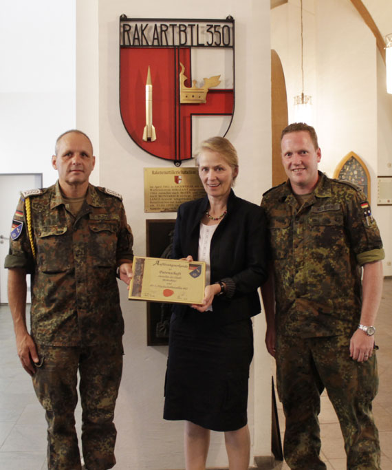 Oberstabsfeldwebel Matthias Pütz (links) und Leutnant Heiko Klassen (rechts) überreichen Stadtbürgermeisterin Gabriele Wieland (Mitte) die Auflösungsurkunde. 