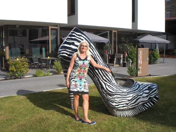 „Da steht ein Zebra auf der Wiese!“ Nun ja, zumindest fast. Denn was ein vorbeilaufendes Kind meinte, ist der Mon-Stiletto „Zebra“, der auf einer Grünfläche im Aubachviertel steht. Die Künstlerin Uschi Geißler hat sich eigens für den Fototermin ein passendes Kleid mit Zebramuster angezogen. Geißler ist Mitglied im Kunstverein Montabaur und gibt Malkurse bei der vhs.   
