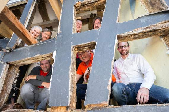 Gemeinsam arbeiten sie an der Sanierung des alten Hauses: (oben v.l.) die Eigentümer Bettina Lindner-Gehrhardt und Dr. André Gehrhardt, Dachdecker Alexander Baldus und Zimmerermeister Thomas Becker, (unten v.l.) Architekt Konstantin Hartenstein sowie Bernd Pöhler und Stefan Baumgarten von der VG Montabaur. (Bild: Sascha Ditscher) 