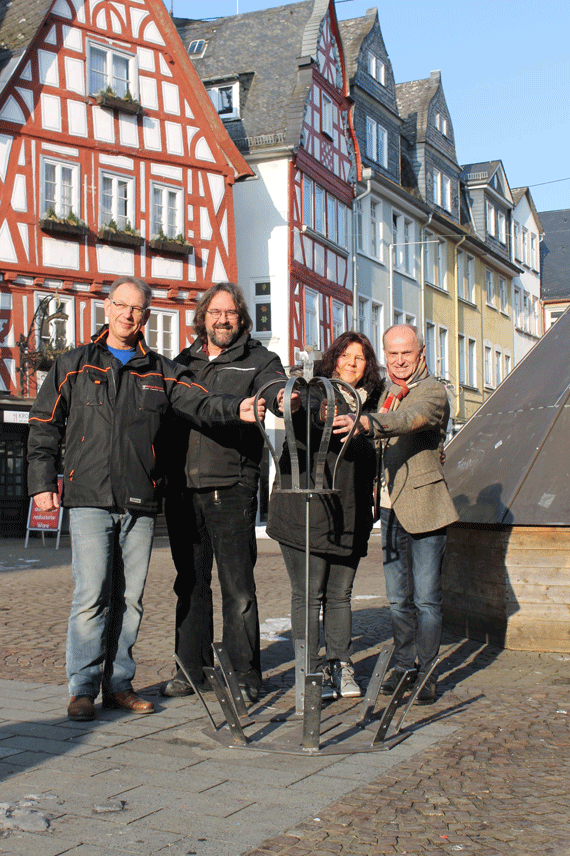 Erste Standprobe für den Osterbrunnen: (v.l.) Schlosser Rainer Girmann hat die Mittelkrone bereits fertig und führte sie vor dem Brunnen auf dem Großen Markt den Akteuren Thomas Becker und Uschi Sturm vom Bürgerverein sowie City-Manager Josef Schüller vor.