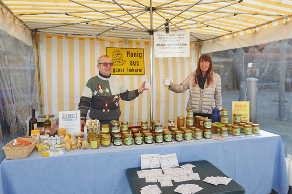 Karin Maas vom Bürgerverein Montabaur und Imker Bernd Schwenzfeier freuen sich über die spontane Frühlingsaktion auf dem Wochenmarkt