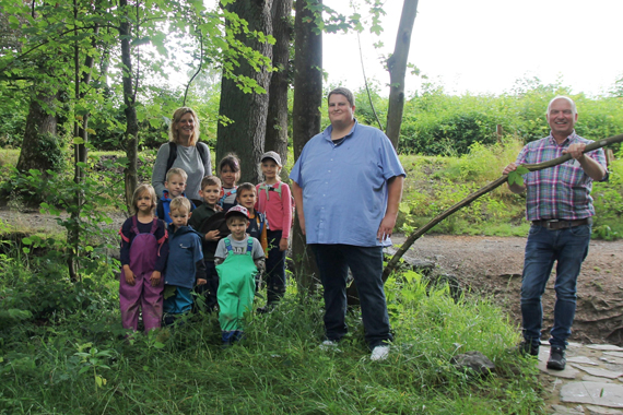 Die Waldkinder der Kita Sonnenschein freuen sich mit ihrer Erzieherin Silke Lehmler über den frisch renovierten Bauwagen im Stadtwald. Bei der Renovierung haben Werkstattanleiter Joachim Vohs vom Projekt JUWEL (r.) sowie Uwe Schmidt vom Förderverein der Kita mitgewirkt. (Bild: Kita Sonnenschein / Tanja Schlicht)