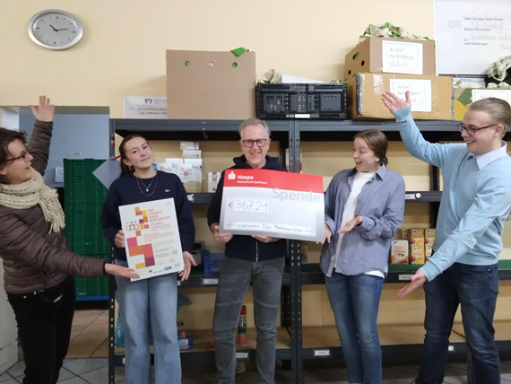 Das Bild zeigt fünf Erwachsene, die mit einem Plakat und einem großen Scheck für die Kamera posieren. (Bild: VG Montabaur / Larissa Metz - mit Selbstauslöser)