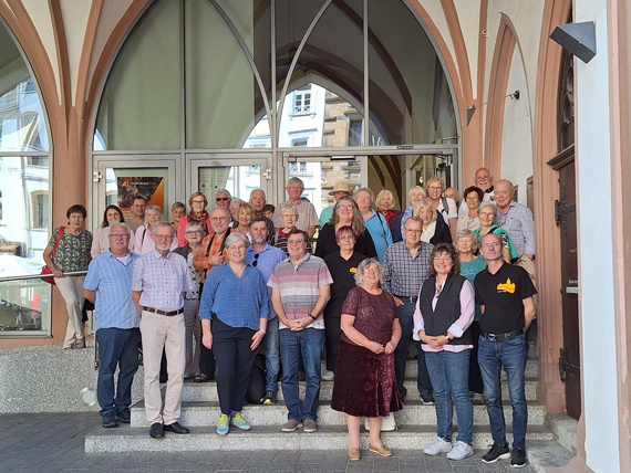 Außenaufnahme einer Gruppe Erwachsener auf den Treppenstufen beim Rathauseingang