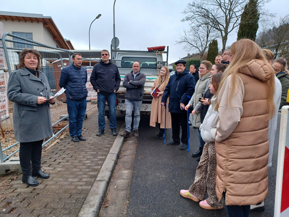 Das Bild zeigt eine Menschengruppe vor einer Baustelle