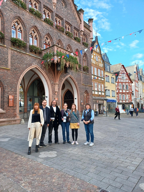 Außenaufnahme einer Gruppe Erwachsener vor dem historischen Rathaus