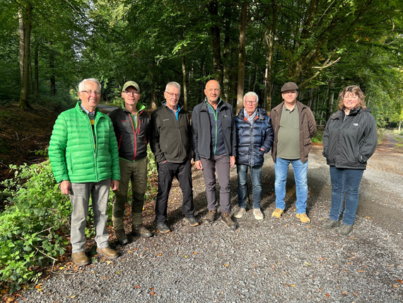 Das Bild zeigt sieben Erwachsene bei einem Waldbegang