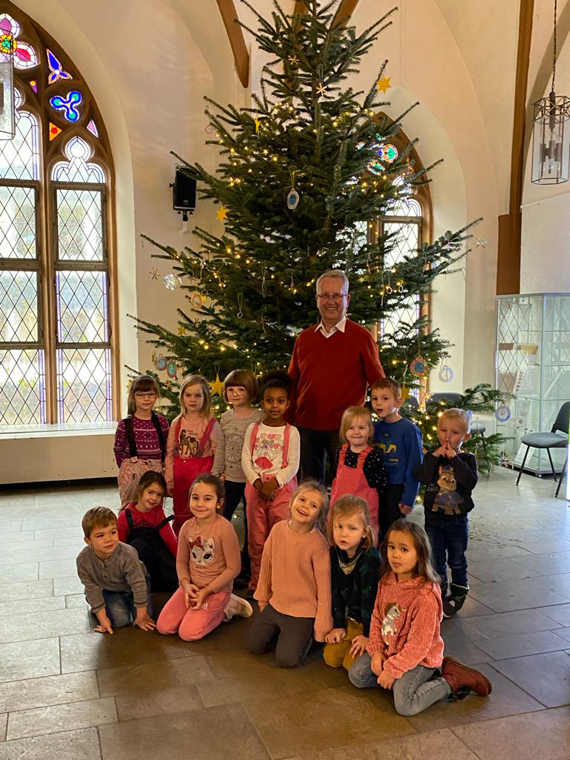 Das Bild zeigt eine Gruppe von Kindergartenkindern mit einem Erwachsenen