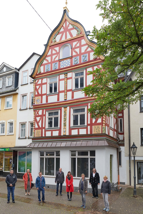 Das frisch sanierte Fachwerkhaus am Kleinen Markt hat eine besonders reich geschmückte Fassade. Ein echter Hingucker. Davor traf sich die Arbeitsgruppe Fachwerkstraße zum Fototermin mit Stadtbürgermeisterin Gabi Wieland (2.v.l.), Tourismusbeauftragten Karin Maas (5.v.l.) und Zimmermann Thomas Becker (7.v.l.) (Bild: Stadt Montabaur / Olaf Nitz)